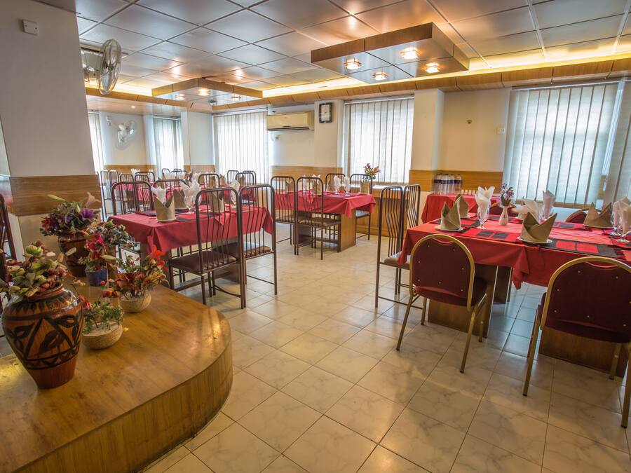 Un restaurante con varias mesas y sillas, dispuesto en un espacio amplio.