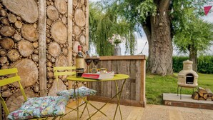 Un espace extérieur aménagé avec des meubles en bois, comprenant une table, des chaises et un livre.