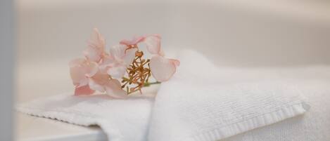 A white towel with a pink flower on it.