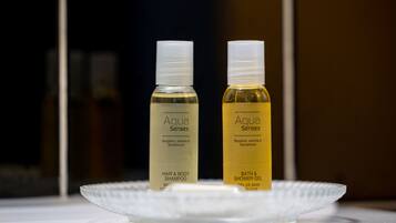 Deux bouteilles de shampooing pour les cheveux et le corps Aqua Senses, ainsi qu’un gel douche, sont présentées sur une assiette blanche.