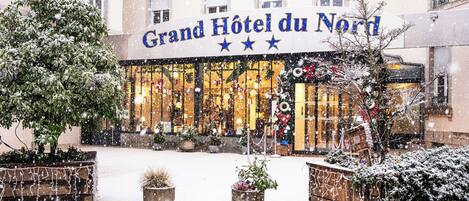 Fachada del Gran Hotel du Nord con plantas y adornos cubiertos de nieve.