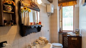 Ein Badezimmer mit Waschbecken, Spiegel, Toilette und einem Fenster mit Blick.