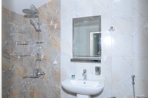 A bathroom with a shower, sink, and mirror.