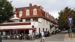 A café with outdoor seating and a sign for 'Pâtisserie'. - central and beachfront apartment in Kühlungsborn East (Kühlungsborn)