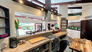 A modern kitchen with a central island, built-in appliances, and a view to the outdoors.