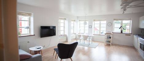 Relax in this stylish living area with a flat-screen TV, comfortable seating, and a fully equipped kitchen.