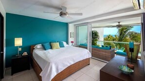 A bedroom with a bed, a nightstand, a table with a bowl, and a balcony with outdoor furniture. - Beautiful Beach front condo Villa Magna (Nuevo Vallarta)