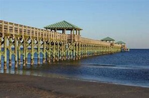 A wooden pier extending into the water with a gazebo structure at the end. - Bay Old Town Cottage-Southern charm & location. (Bay St Louis)
