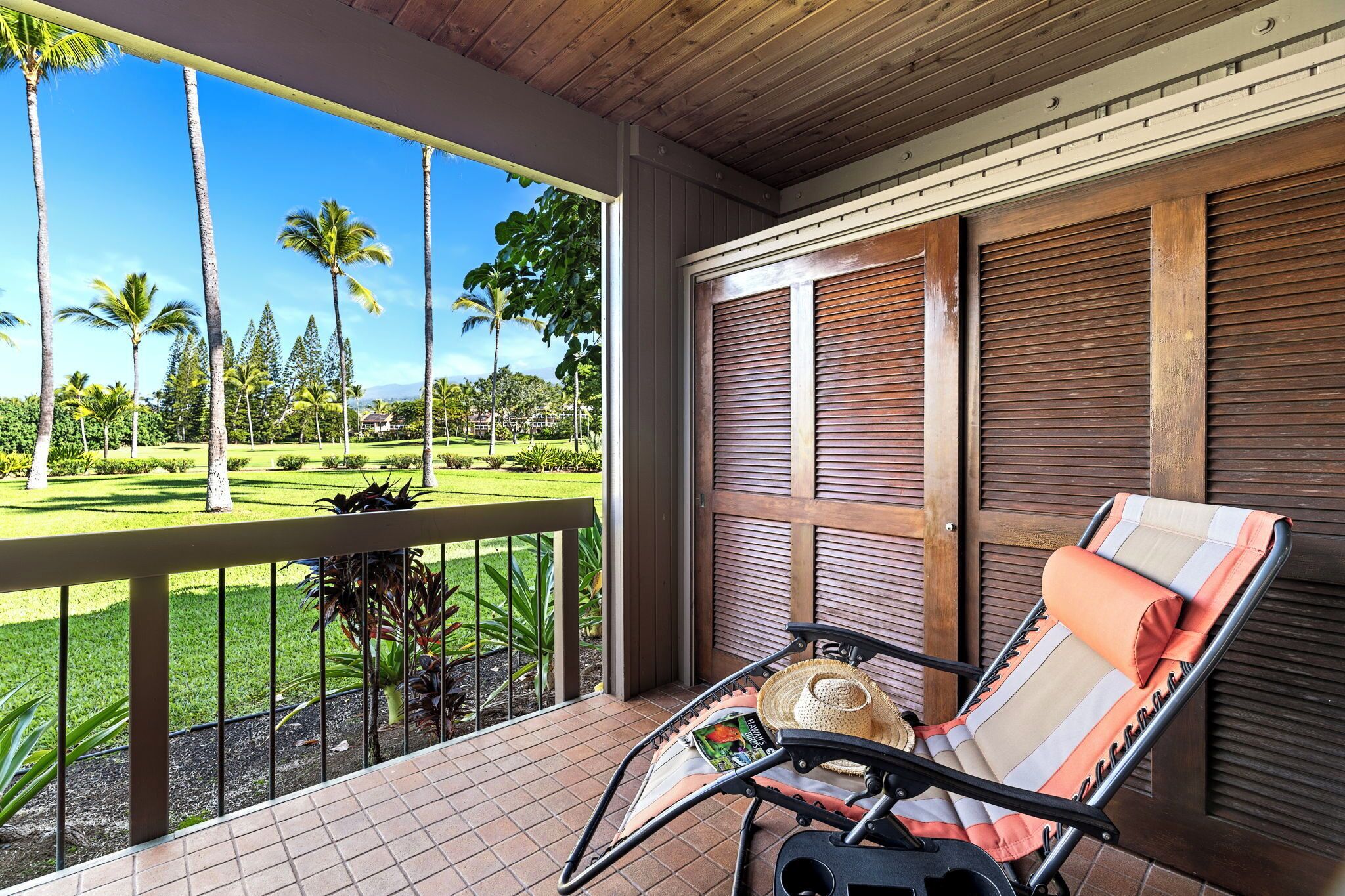 A balcony with a chair, a hat, and a magazine.