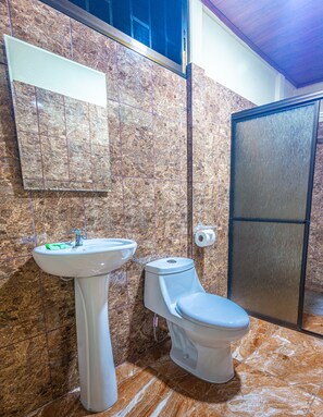 Habitación triple estándar, varias camas, vista al jardín | Baño | Tina y regadera independientes, amenidades de baño gratuitas, toallas 