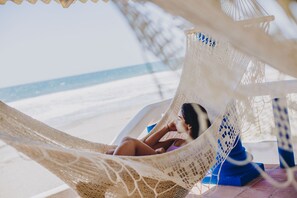 Rannalla, aurinkotuoleja, rantapyyhkeitä