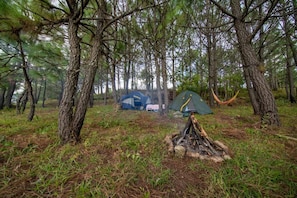 Un campamento con tiendas de campaña y una fogata.