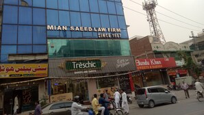 A building with a sign for 'Mian Saeed Law Firm' and 'Treschic' bakery. - City Palace One (Lahore)