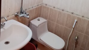 A bathroom with a sink, toilet, and shower. - City Palace One (Lahore)