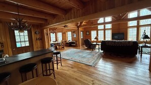 Une cabane en bois spacieuse, dotée d’un grand espace repas, d’un salon confortable et d’un coin bar.