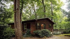 A rustic cabin with a wooden exterior, a porch, and a small deck.