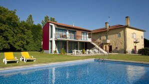 A pool area with a modern building, outdoor seating, and a staircase leading to a second floor. - Quinta do Casal de S. Miguel de Soutelo (Vila Verde)