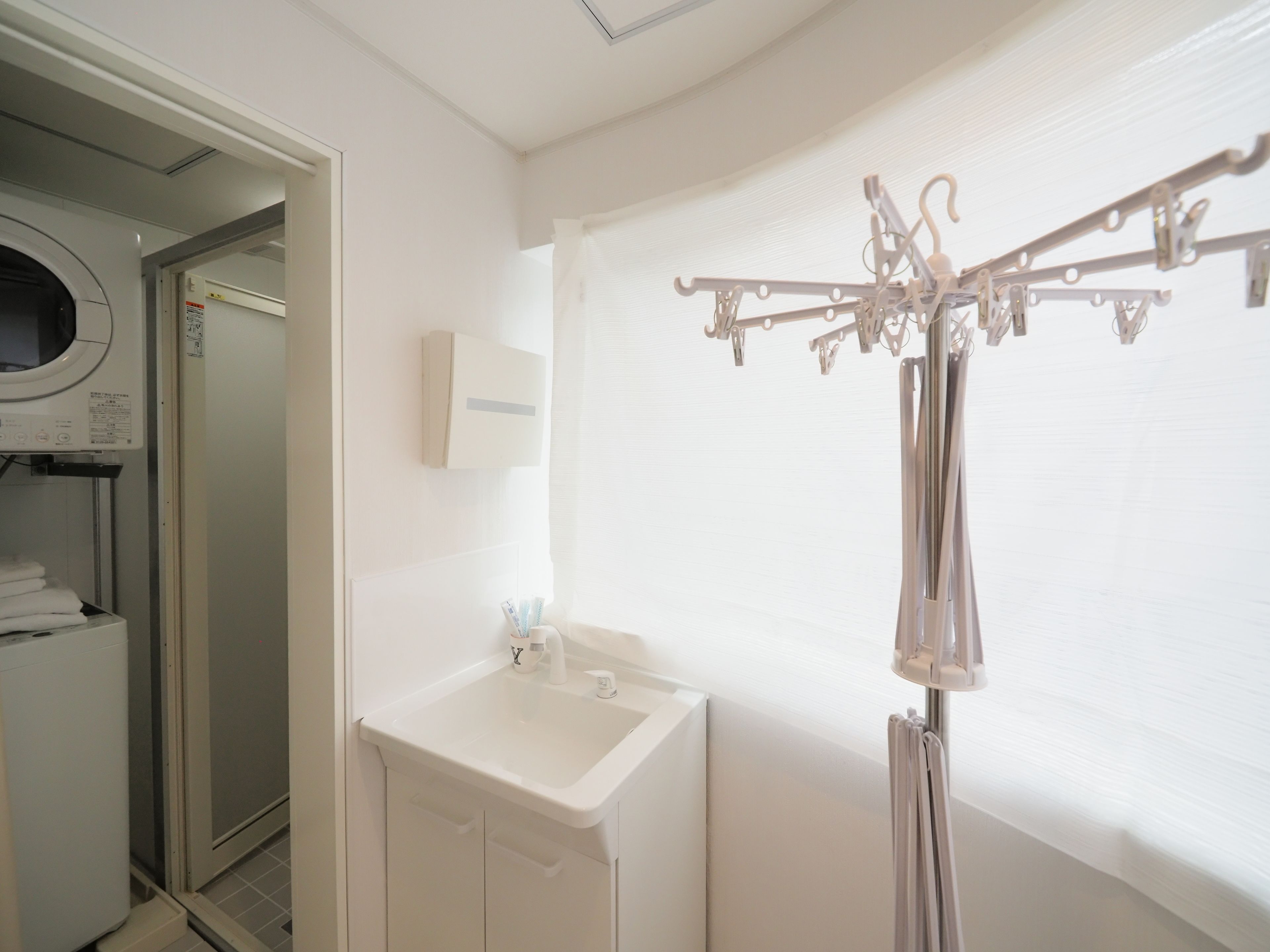 A bathroom with a white sink, a mirror, and a towel rack.