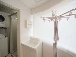 Une salle de bain avec un lavabo blanc, un miroir et un porte-serviettes.