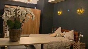 Une chambre à coucher moderne avec un lit, une table de chevet et un lustre.