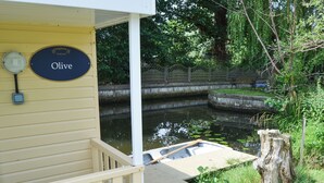 Un chantier naval appelé « Olive », doté d’un quai en bois et d’un petit bateau.