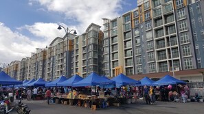 A market area with blue tents and people shopping.