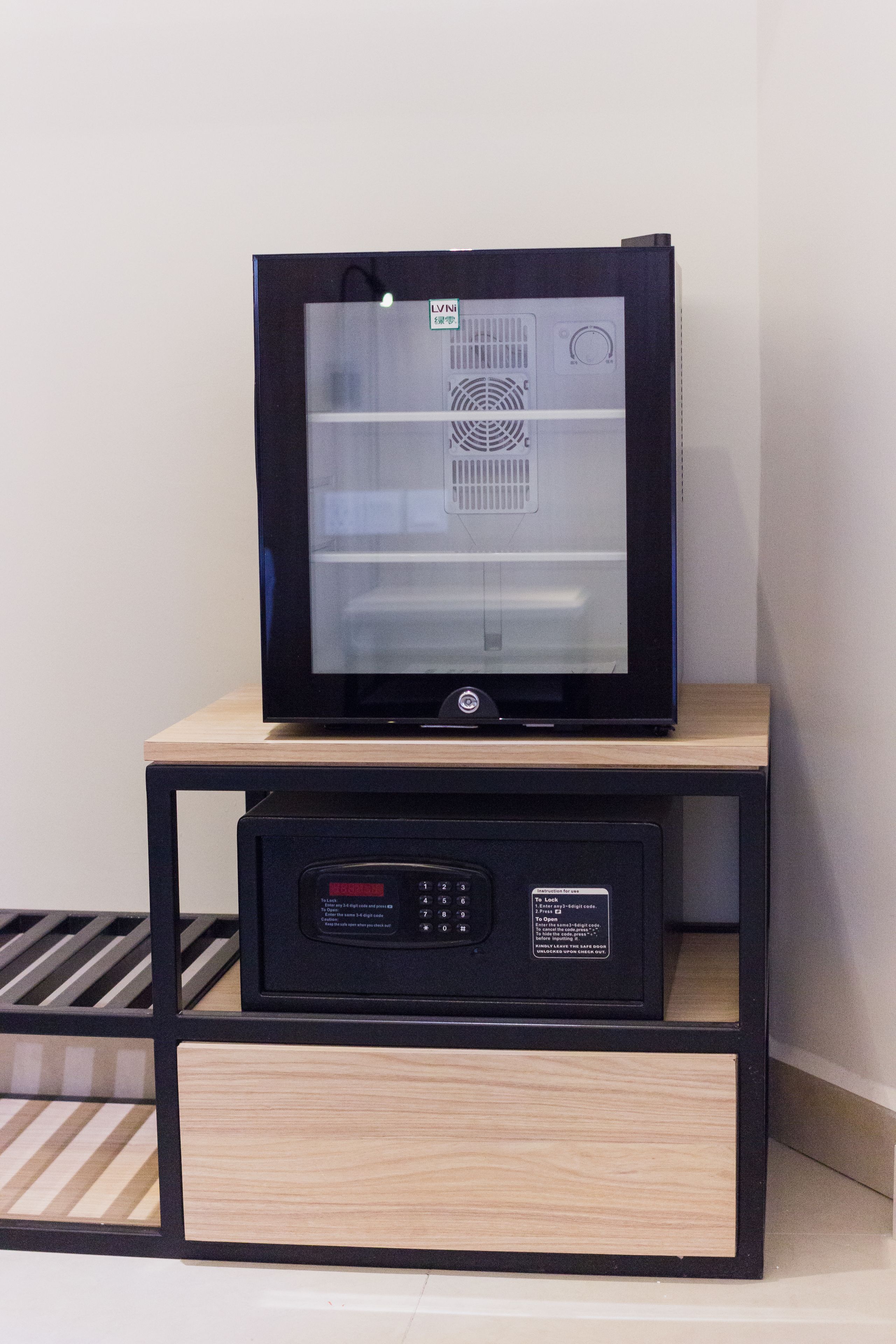 Un televisor sobre un pedestal de madera, con un panel de control debajo.