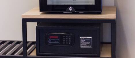 Un televisor sobre un pedestal de madera, con un panel de control debajo.