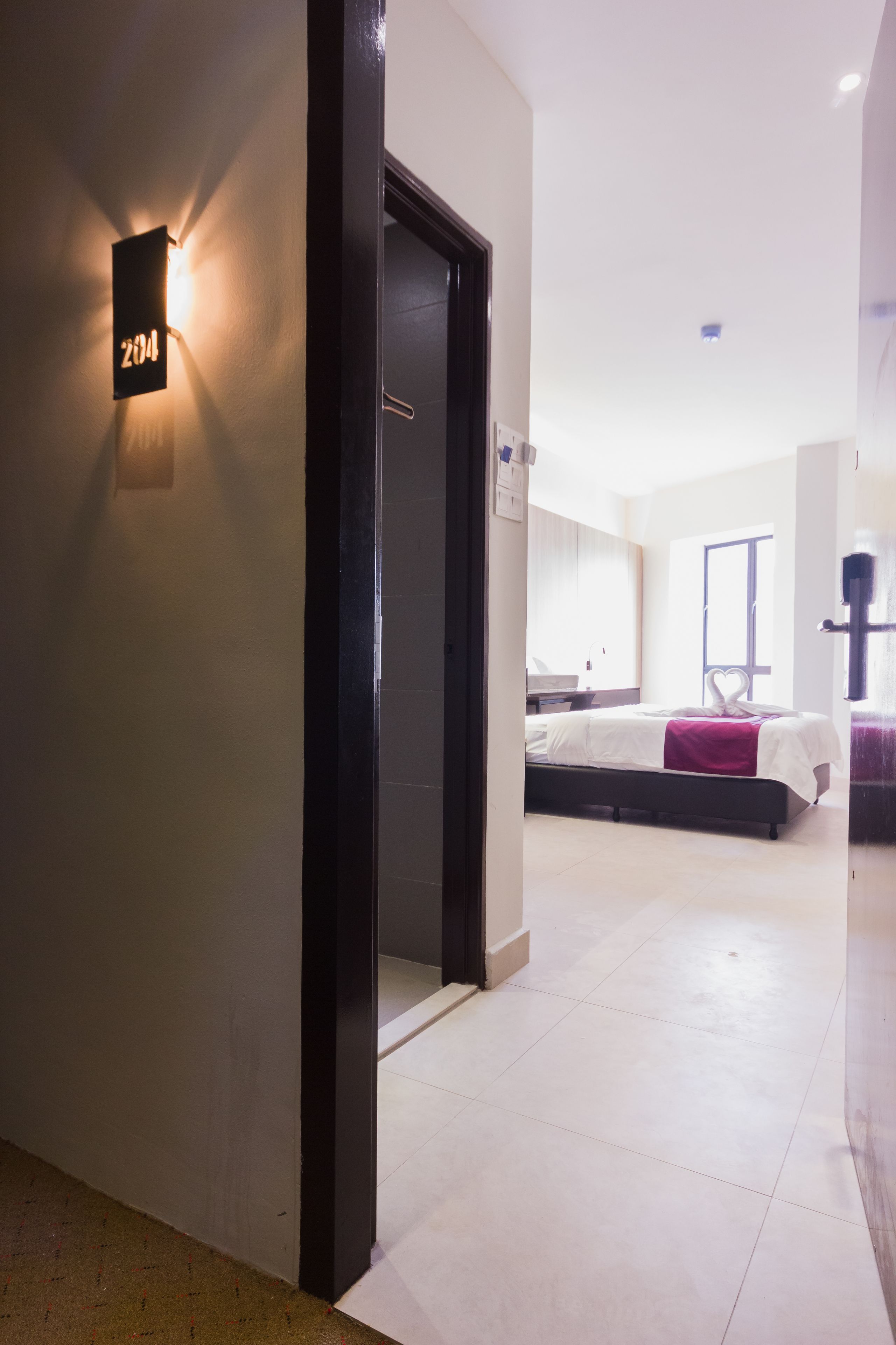 Una habitación de hotel con una cama, un escritorio y una ventana.