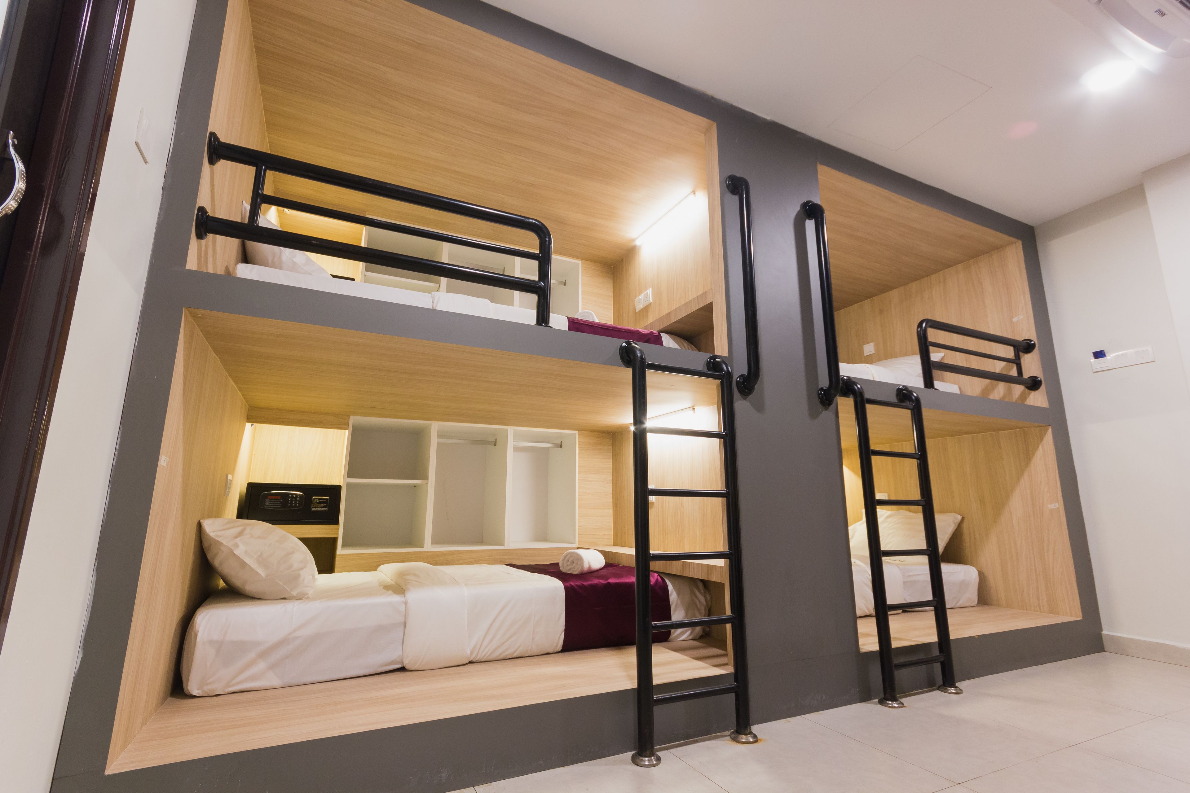 A bunk bed room with a desk and a wardrobe.