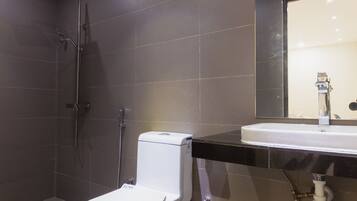 A modern bathroom with a toilet, shower, and sink.