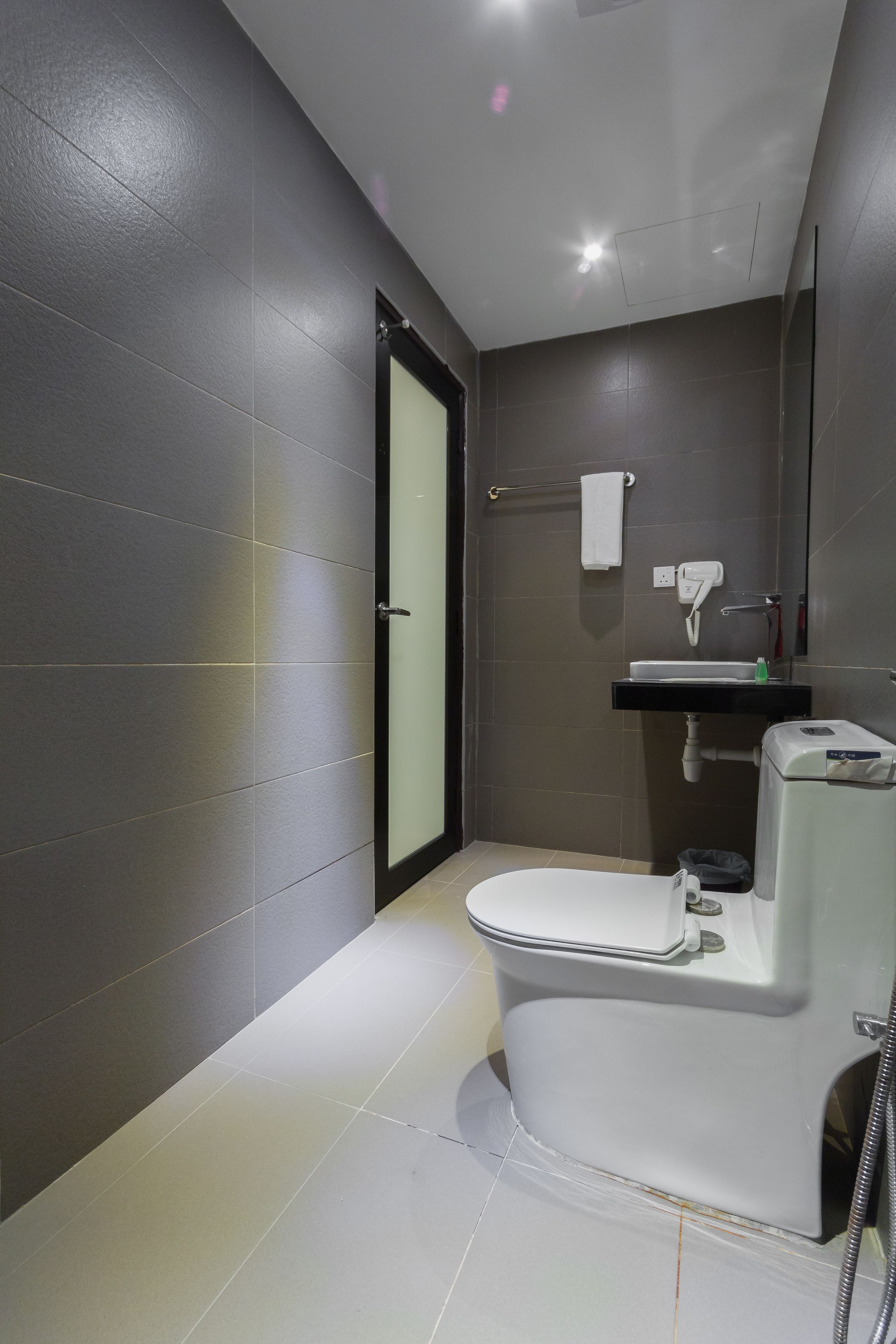 A modern bathroom with a toilet, sink, and shower.
