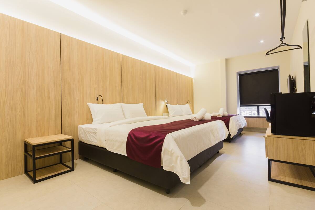 A modern bedroom with a large bed, a bedside table, and a TV.