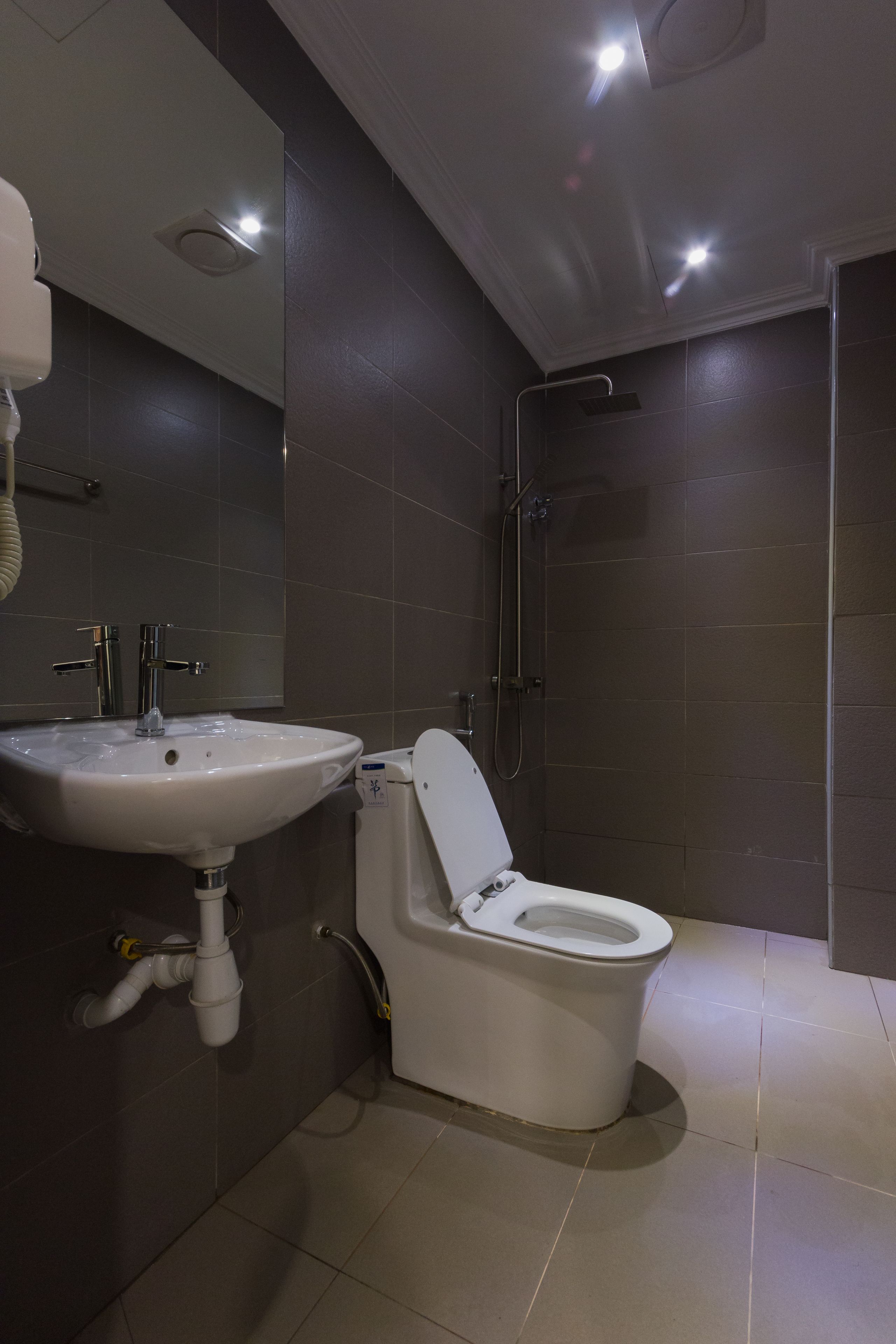 A modern bathroom with a white sink, toilet, and shower.