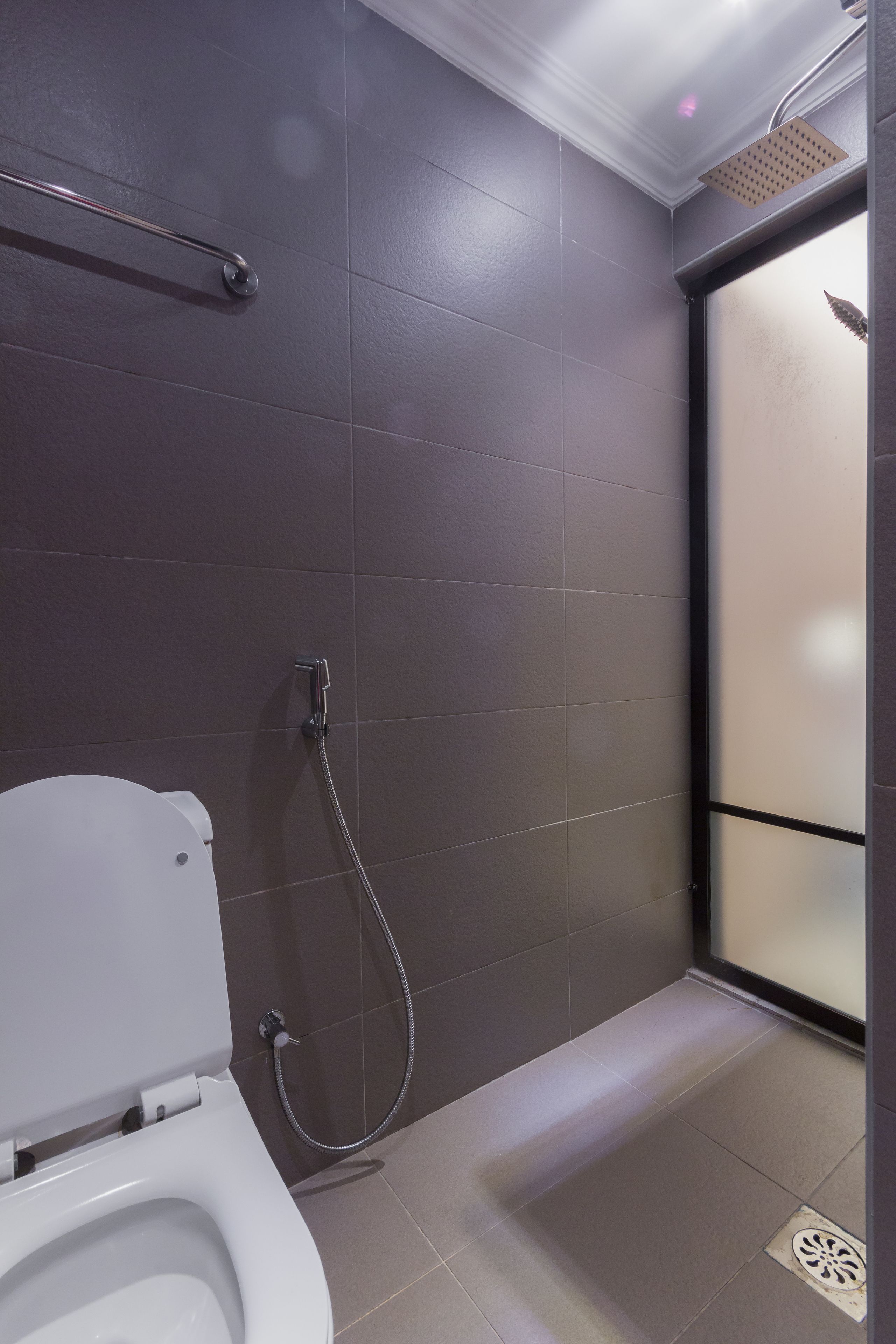 Ein modernes Badezimmer mit Toilette, einer Duschkabine mit Glastür und Fliesenboden.
