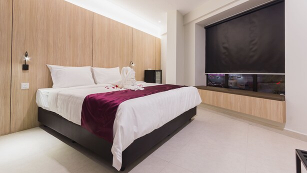 Um quarto moderno com uma cama grande, painéis de madeira, televisão integrada e uma janela com vista para a cidade.