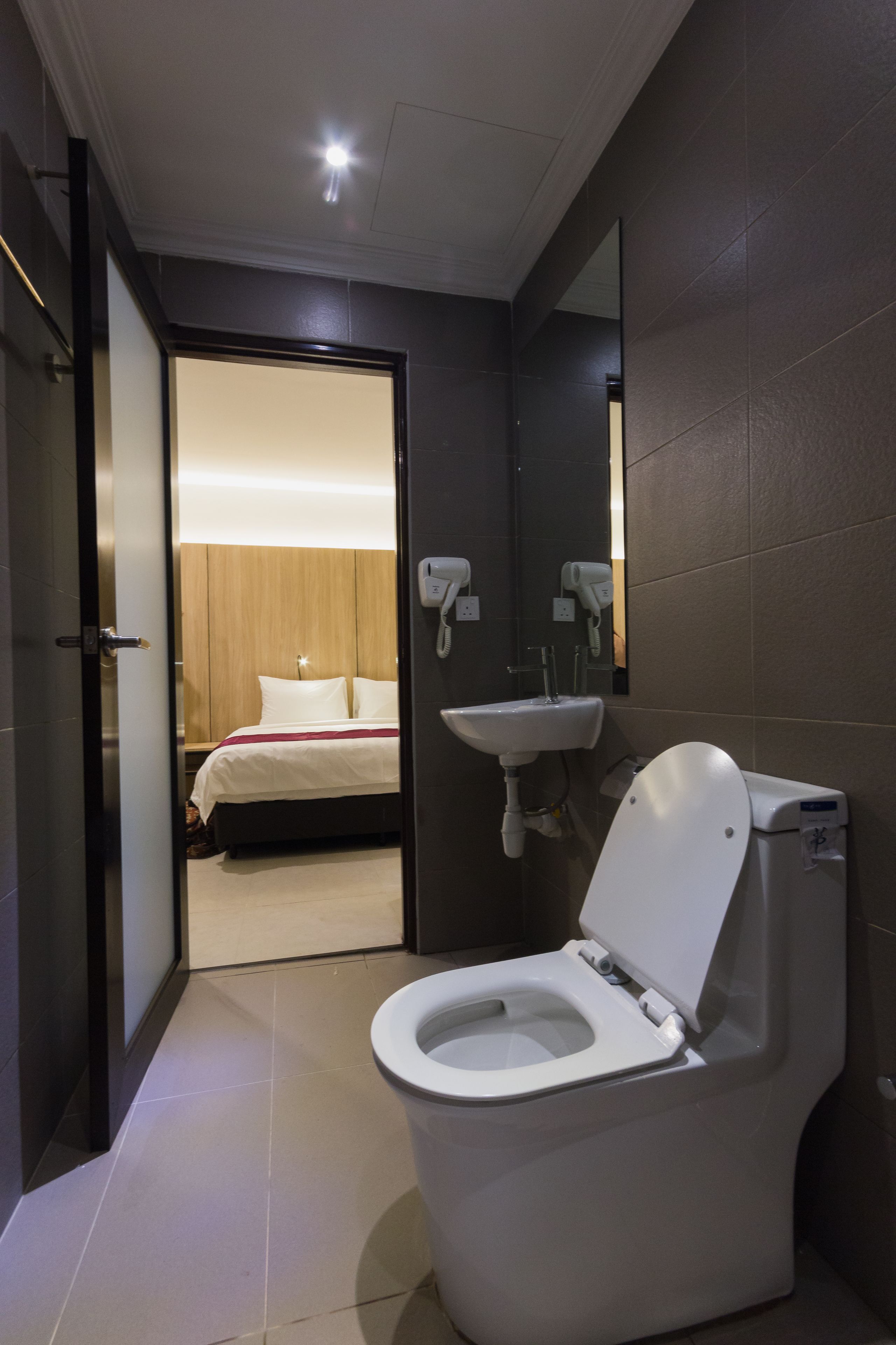 A modern bathroom with a toilet, sink, and a mirror.