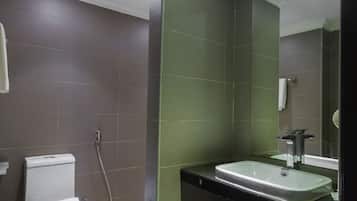 A modern bathroom with a toilet, sink, and mirror.