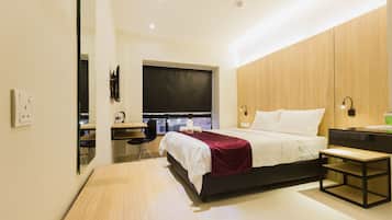 Un dormitorio moderno con cama, mesita de noche y escritorio con silla.
