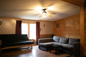 Family Lodge | Living area - Pere Marquette River KOA Campground (Branch)