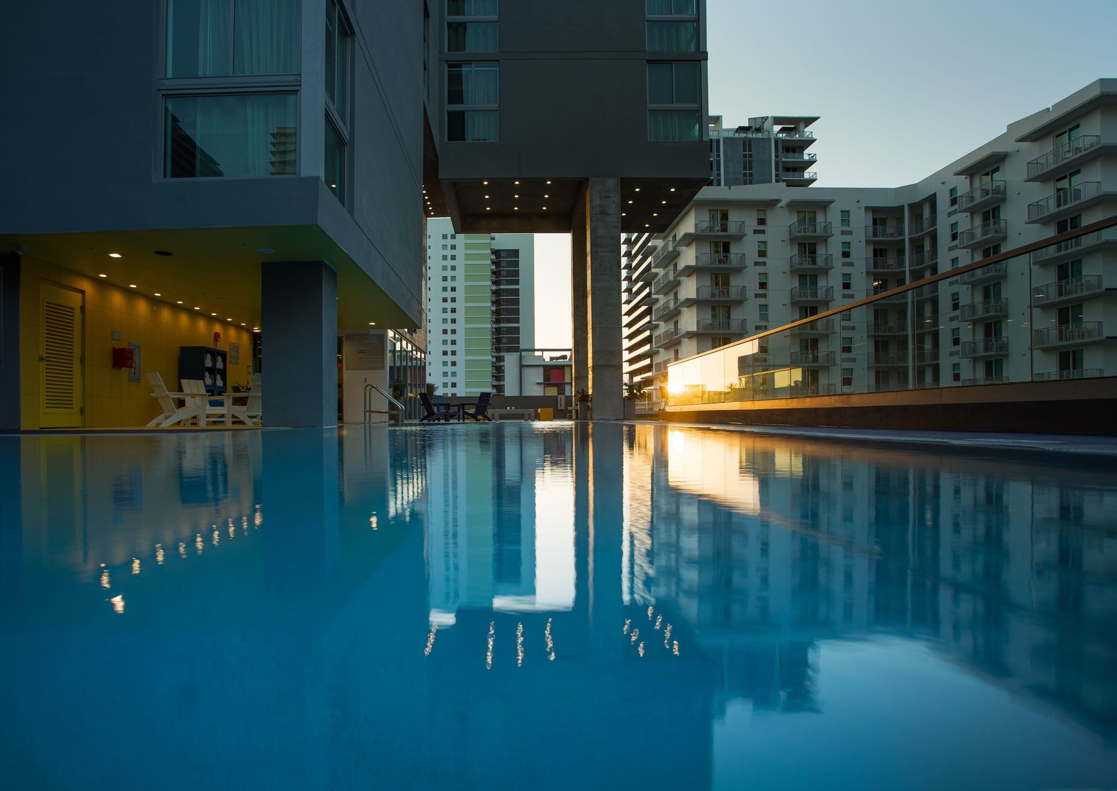 Un hôtel moderne doté d’une piscine, de plusieurs étages et offrant une vue sur le coucher de soleil.