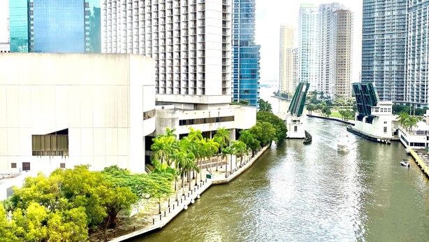 A river with buildings on both sides, including a prominent white building with a modern design. - Hotel Indigo Miami Brickell by IHG (Miami)