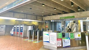 A subway station with turnstiles, a ticket machine, and various signs including one for Miami-Dade County. - Hotel Indigo Miami Brickell by IHG (Miami)