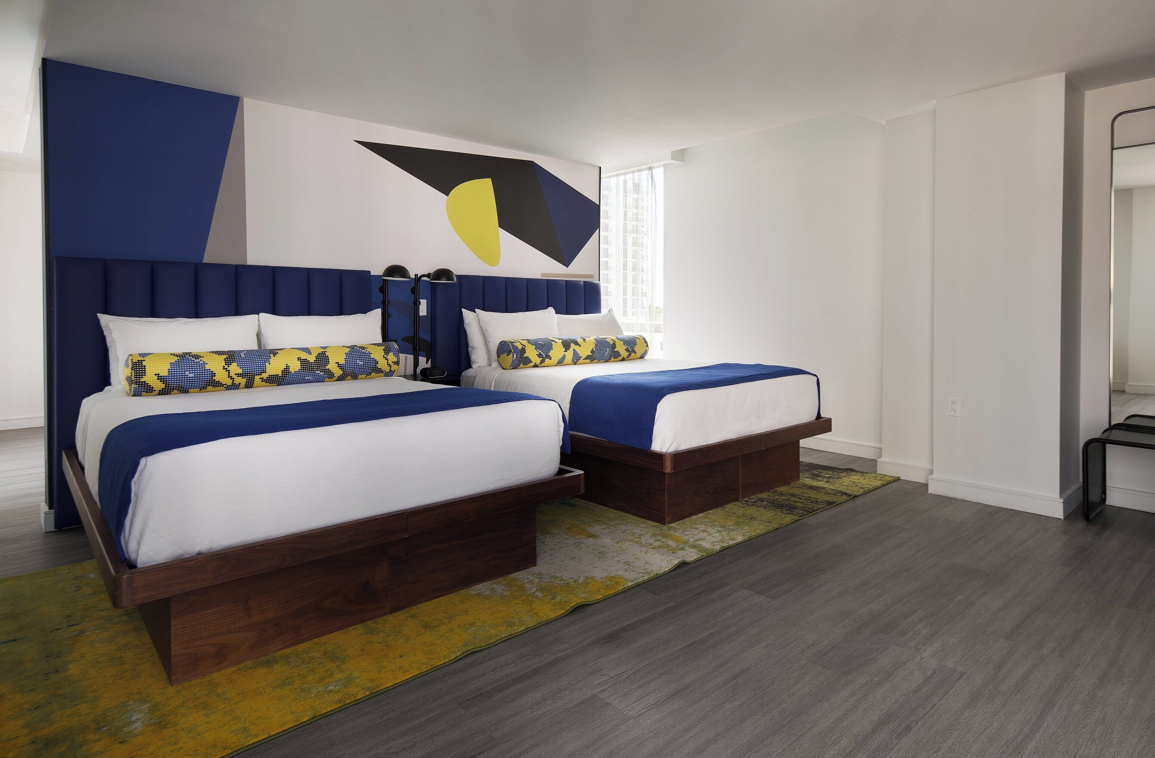 A modern bedroom with a large bed, two bedside tables, and a unique wall art piece.