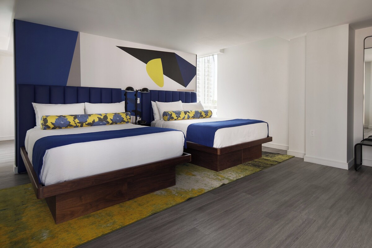 A modern bedroom with a large bed, two bedside tables, and a unique wall art piece.