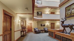 A spacious lobby with a high ceiling, wooden accents, and a central seating area with leather chairs. - Newly Renovated 2 Bed/ 2 Bath Beaver Creek  2 Bedroom Condo by RedAwning (Avon)