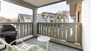 A balcony with a grill, chairs, and a small table. - Nine Vail Road Condos in Heart of Vail Village by RedAwning (Vail)
