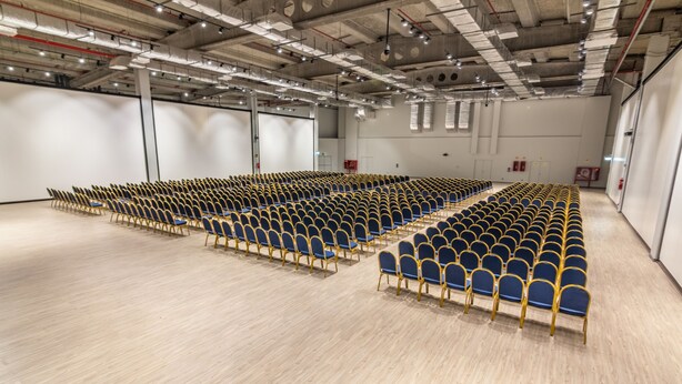 A large indoor space with rows of blue and gold chairs arranged for seating. - MDS Hotel Chillan (Chillan)