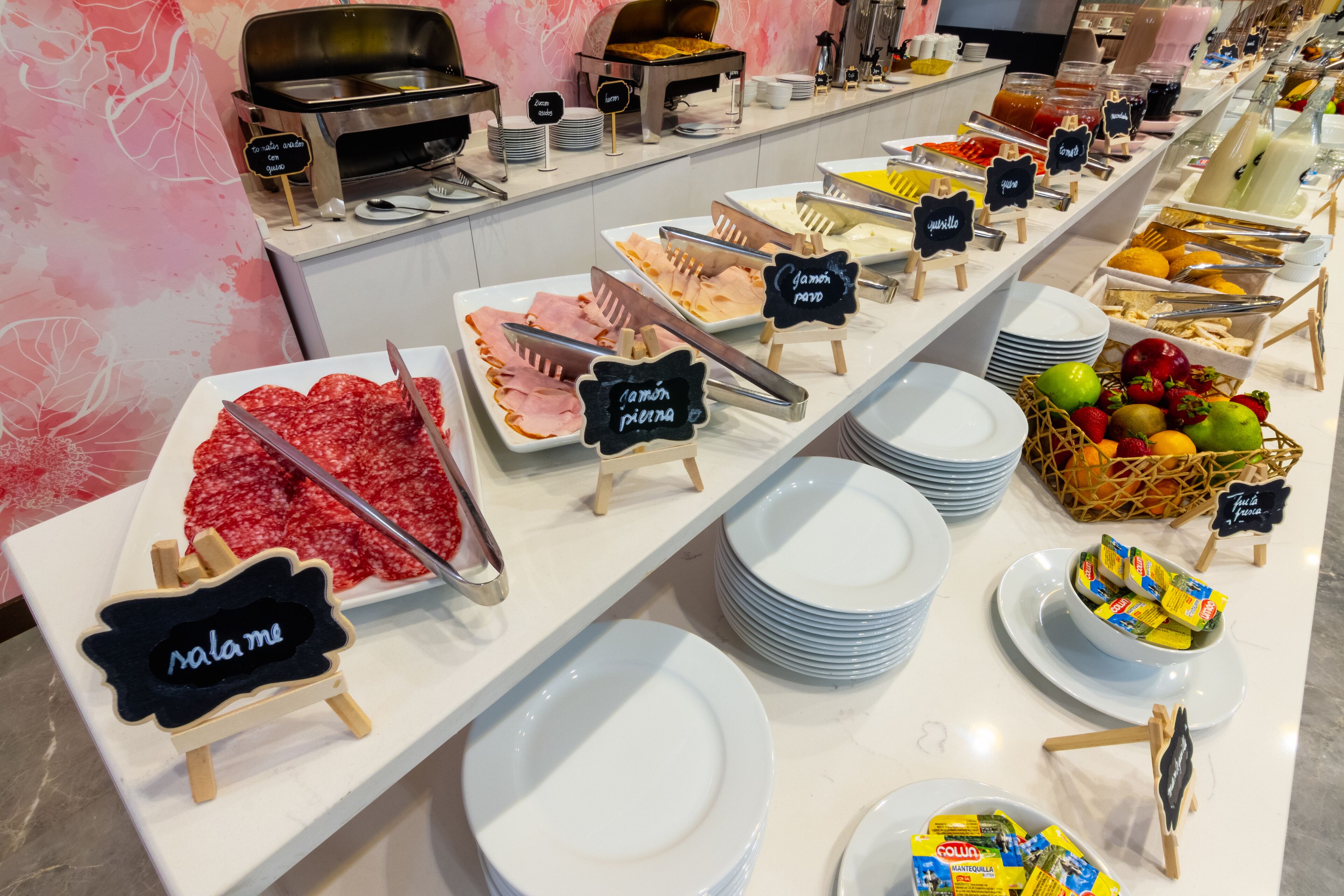Un bufé con diversas opciones de comida y utensilios.