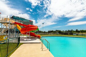 Una piscina cubierta, una piscina al aire libre, tumbonas
